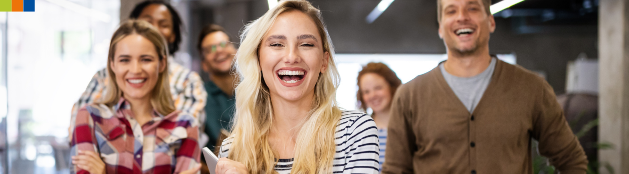 Lachende Mitarbeitende unterschiedlicher Herkunft, die zusammenarbeiten und eine positive Teamatmosphäre zeigen