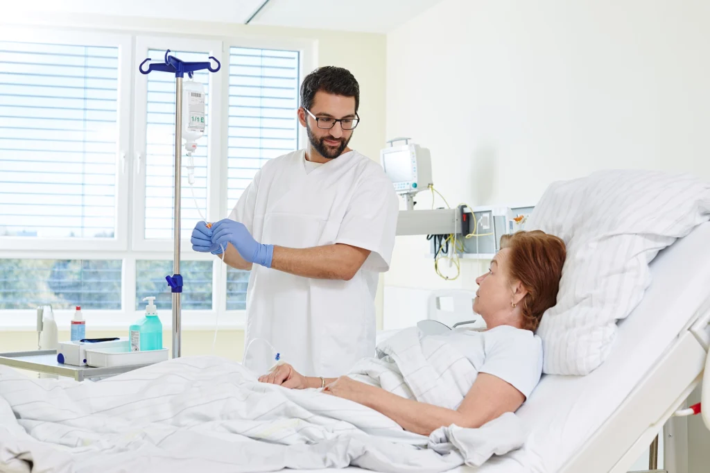 Medizinische Pflegekraft versorgt ältere Person im Krankenhaus.